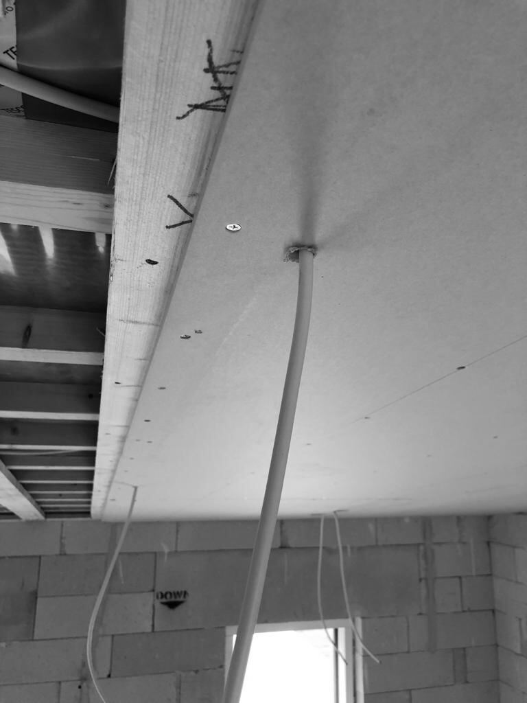 A lighting-point cable pulled into a new ceiling before the boards are closed up.